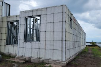 Partially constructed building with concrete blocks and metal window frame.