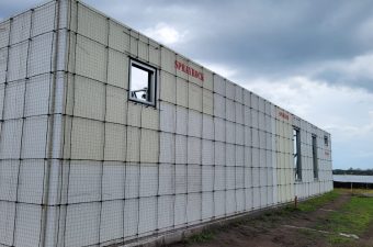 A concrete wall under construction with an open window frame.