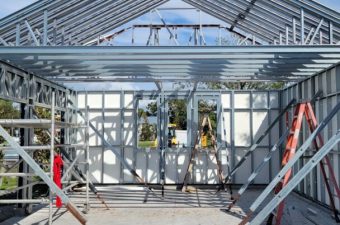 Construction of a steel frame building underway on a sunny day.