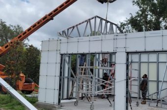 Construction workers assembling a steel frame on a building site.