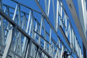 Close-up of a modern steel bridge structure against blue sky.