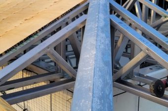 Structural steel beams forming a roof framework inside a building.