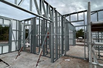 Steel frame structure under construction on concrete foundation.
