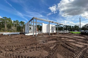 Foundation and steel frame of a building under clear blue sky.