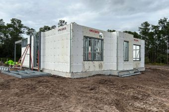 Concrete foundation and walls of a house under construction.