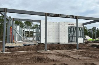 Construction site with concrete walls and steel beams in place.