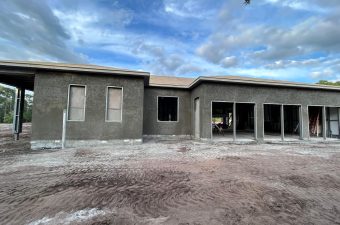 Single-story house shell with stucco walls