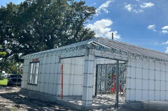 A partially constructed building made of white concrete blocks under a blue sky.