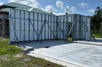Concrete slab with a partially built metal and wood framework against a blue sky.