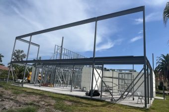 Steel building frame under construction with blue sky
