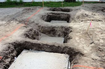 Excavated foundation trenches in soil for building construction.