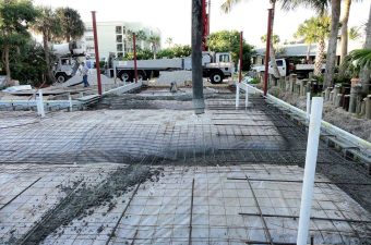 Concrete being poured and leveled for a new sidewalk.