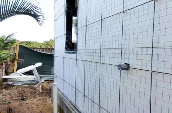 White tiled wall with a net and an outdoor chair nearby.