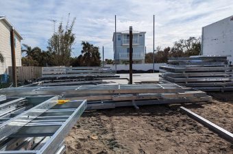 Construction site with metal beams and a building in progress.