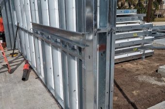 Metal stud framing for a wall under construction on a concrete floor.