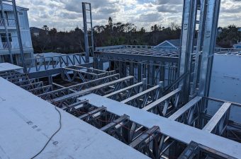 Steel framework construction on a rooftop under a cloudy sky.