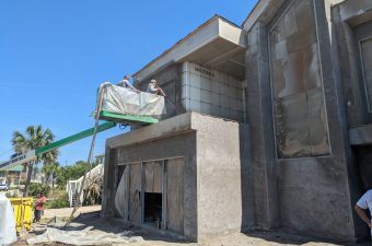 Concrete structure under construction with exposed pipes and unfinished surfaces.
