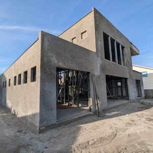 Unfinished concrete building under clear blue sky.