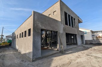Unfinished concrete building under clear blue sky.