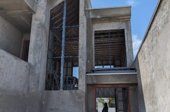 A concrete building under construction with exposed brick and unfinished walls.