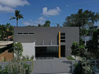 Modern house with clean lines and a minimalist facade under a blue sky.