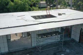 Construction site with workers on a flat rooftop under development.