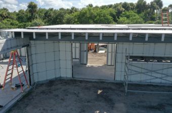 Partially constructed building with insulation panels and scaffolding.
