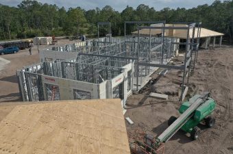 Construction site with steel framing and concrete walls in progress.