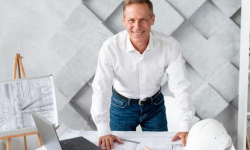 Man examining construction plans at desk